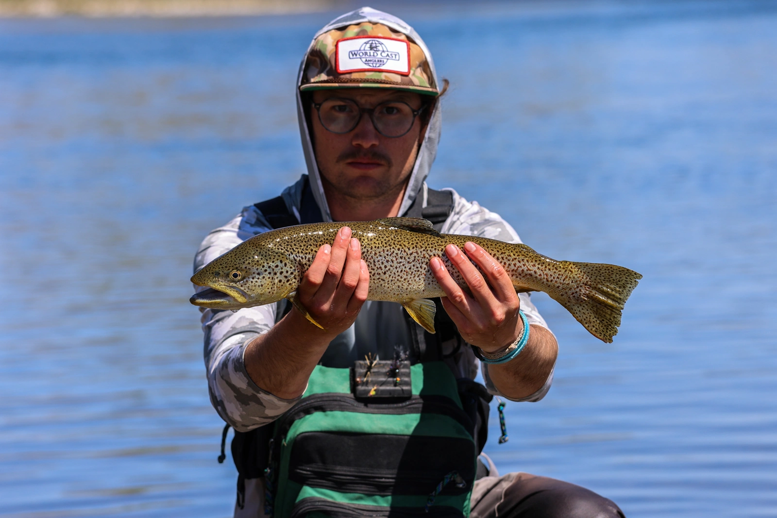 man holding fish on fly fishing ranch in wyoming