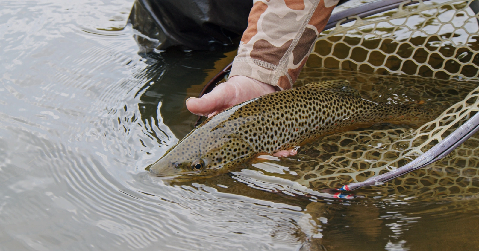 man holding fish on hunting ranch in colorado